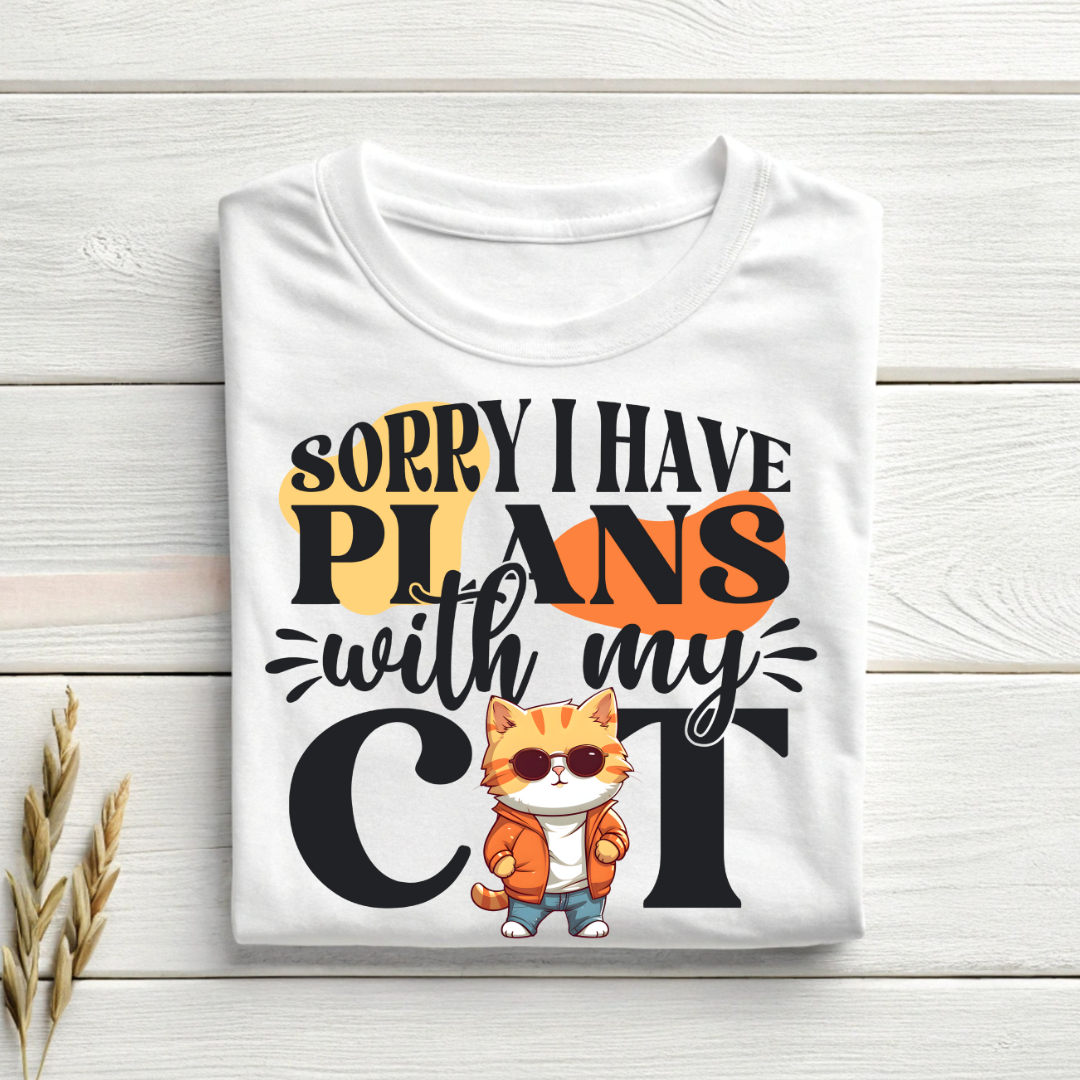 White t-shirt with a cat graphic and text on a wooden surface