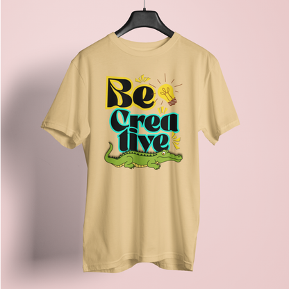 Beige t-shirt with 'Be Creative' text and alligator graphic on a pink background