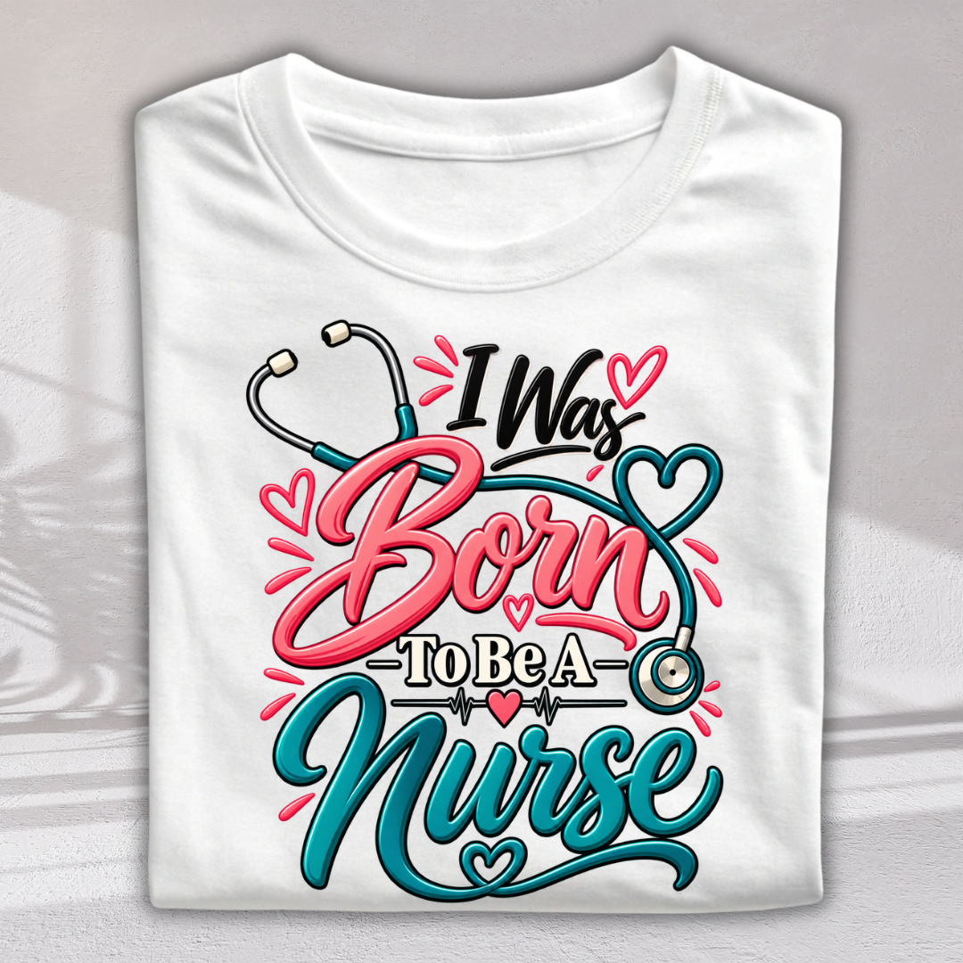 A folded white t-shirt with a colorful graphic print that reads 'I Was Born To Be A Nurse' in pink, teal, and black lettering, decorated with stethoscope and heart motifs.