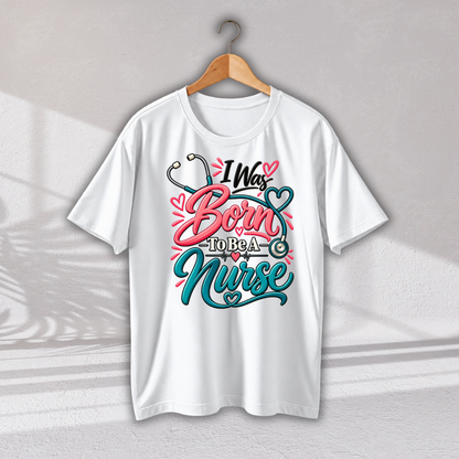 A white short-sleeve t-shirt hanging on a wooden hanger against a light gray wall. The shirt features a colorful graphic on the front with the text 'I Was Born To Be A Nurse' in pink and teal lettering, decorated with a stethoscope and heart motifs.