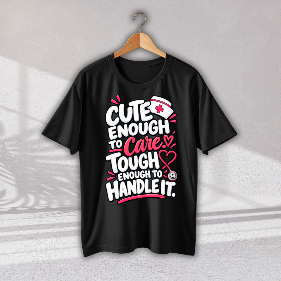 A black short-sleeve t-shirt hanging on a wooden hanger against a light gray wall. The shirt features a graphic print with the text 'CUTE ENOUGH TO Care, TOUGH ENOUGH TO HANDLE IT.