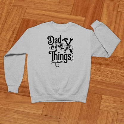 Gray sweatshirt with 'Dad Fixer of Things' text on a wooden floor