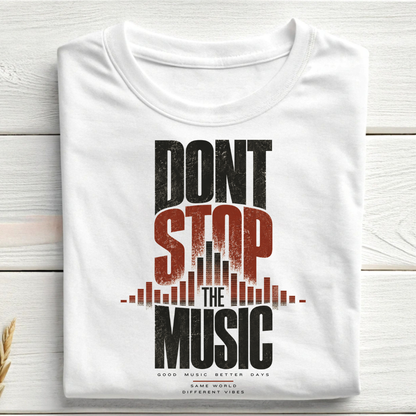 A folded white t-shirt with a distressed graphic print reading 'DONT STOP THE MUSIC' in black and red, styled on a light wood plank background.