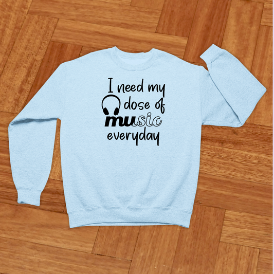 Light blue sweatshirt with text on a wooden floor