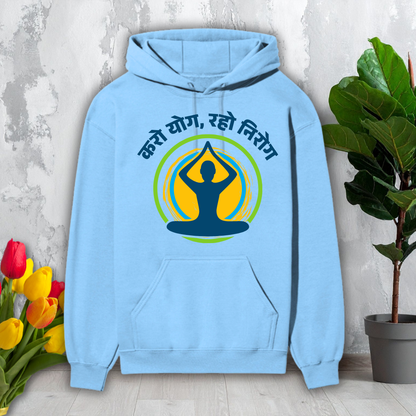 Light blue hoodie with yoga design and text on a gray surface with flowers and a plant.