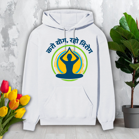 White hoodie with yoga-themed design on a light gray surface with flowers and a plant.
