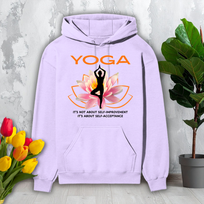 Purple hoodie with yoga design and text on a light gray surface with flowers and a plant.