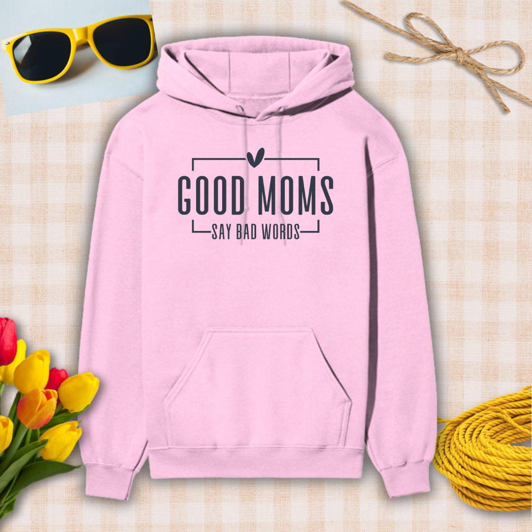 Pink hoodie with 'Good moms say bad words' text on a checkered background with sunglasses, tulips, and twine.