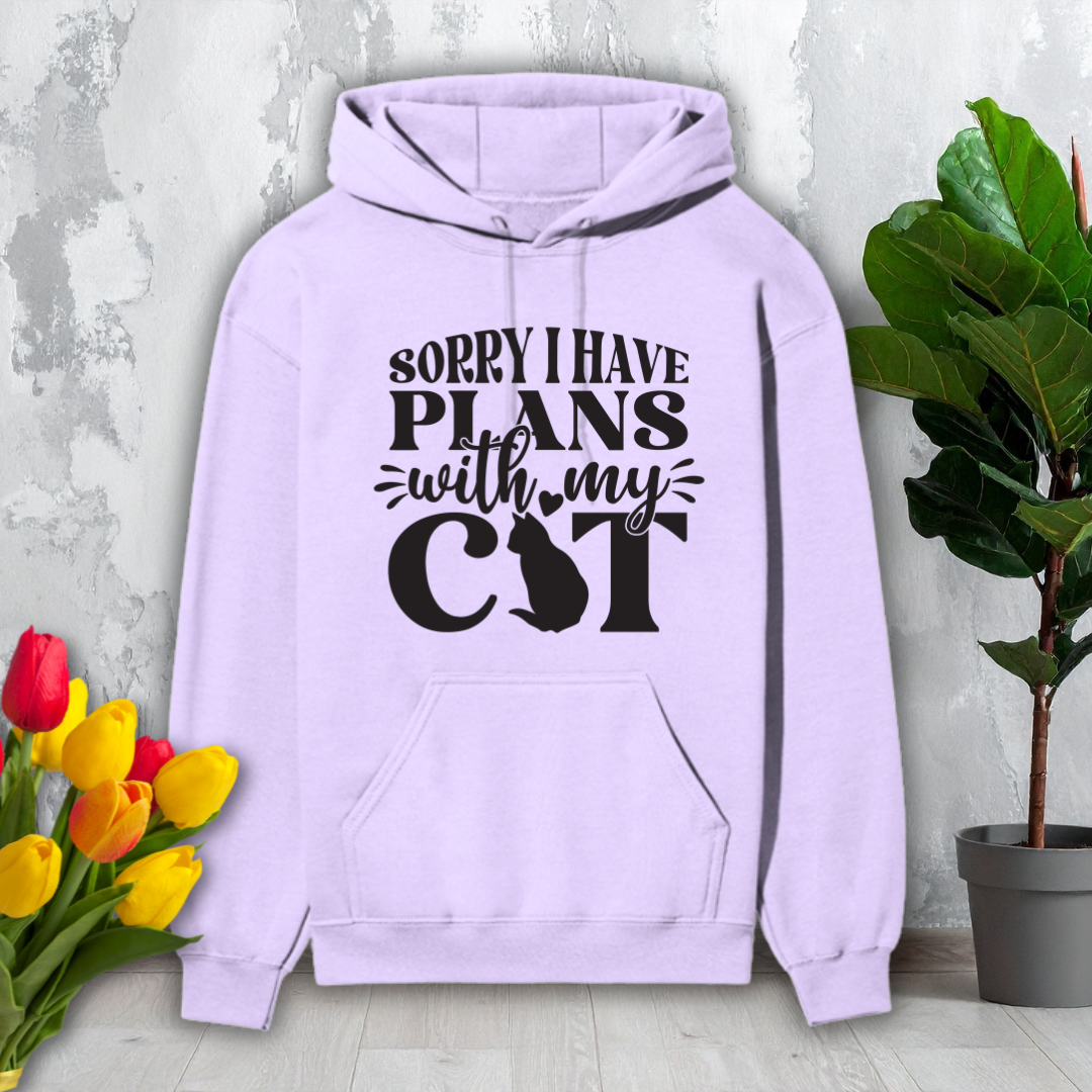 Light purple hoodie with text 'Sorry I have plans with my cat' on a light gray background with flowers and a plant.