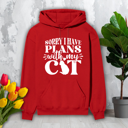 Red hoodie with 'Sorry I have plans with my cat' text on a light gray background with flowers and a plant.