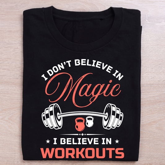 Black t-shirt with gym-themed text and graphics on a wooden surface