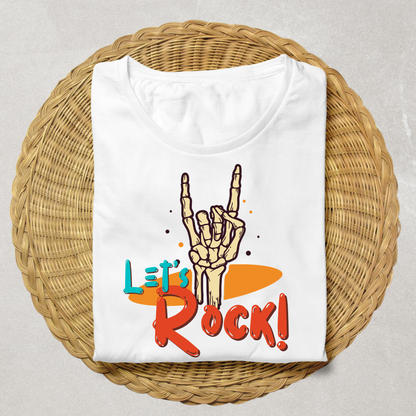 A folded white t-shirt with a 'Let's Rock!' graphic featuring a skeleton hand making the rock on gesture, displayed on a round woven straw mat against a neutral gray background.