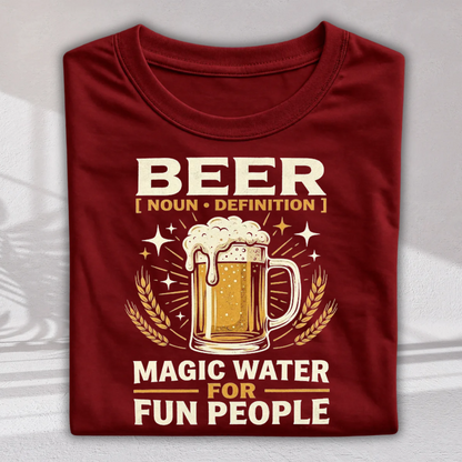 A folded maroon crewneck t-shirt with a graphic print featuring a beer mug, wheat stalks, and the text 'BEER [ NOUN • DEFINITION ] MAGIC WATER FOR FUN PEOPLE' in cream and gold lettering.