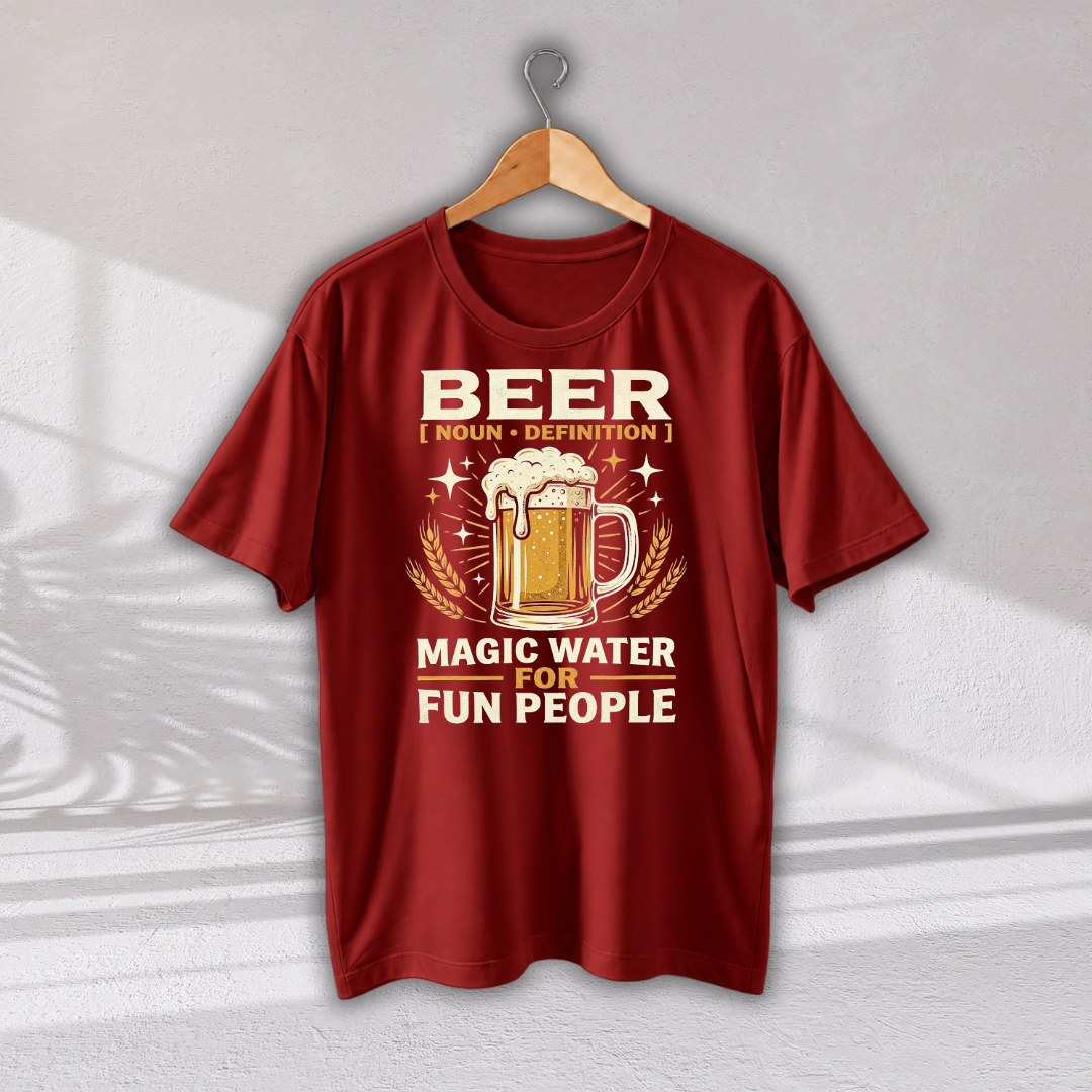 A red short-sleeve t-shirt hanging on a wooden hanger against a light gray wall. The shirt features a graphic print with a beer mug, wheat ears, and the text 'BEER [ NOUN • DEFINITION ] MAGIC WATER FOR FUN PEOPLE' in cream and gold tones.