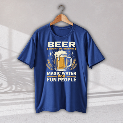 A royal blue short-sleeve t-shirt hanging on a wooden hanger against a light gray textured wall. The shirt features a graphic print with a beer mug, wheat ears, and the text 'BEER [ NOUN • DEFINITION ] MAGIC WATER FOR FUN PEOPLE'.