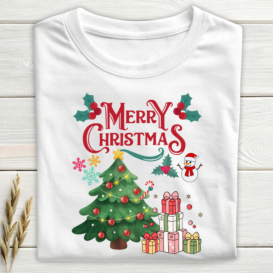 White t-shirt with Christmas-themed design featuring a tree, presents, and snowman on a wooden surface.