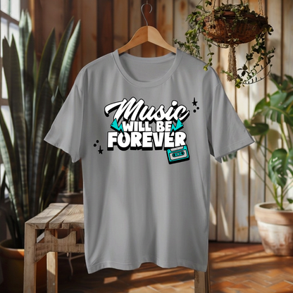 A light gray short-sleeve t-shirt hanging on a wooden hanger in a rustic indoor setting with plants and wood paneling. The shirt features a graphic on the chest that reads 'Music WILL BE FOREVER' in stylized white and black lettering with teal accents and a cassette tape illustration.