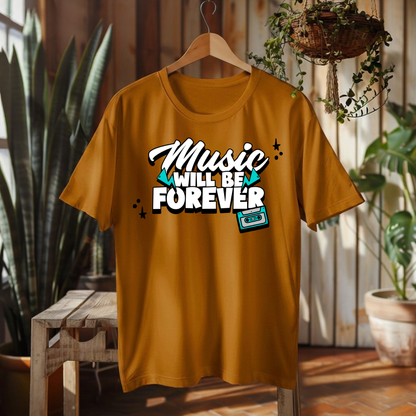 A mustard yellow t-shirt hanging on a wooden hanger in a rustic indoor setting with plants and a wooden bench. The shirt features a graphic print that reads 'Music WILL BE FOREVER' in stylized white and teal lettering with a retro cassette tape illustration.