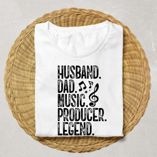 A folded white t-shirt with black text reading 'HUSBAND. DAD.'