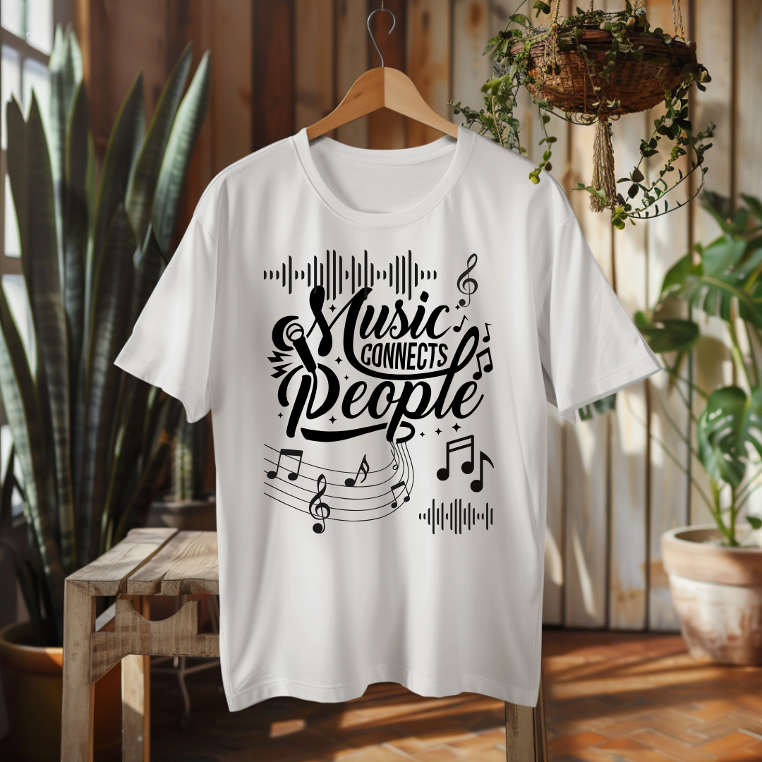 A white short-sleeve t-shirt hanging on a wooden hanger, featuring a black graphic print that reads 'Music Connects People' with musical notes and staff lines. The shirt is displayed in a warm, rustic indoor setting with wooden walls, potted plants, and a wooden bench.