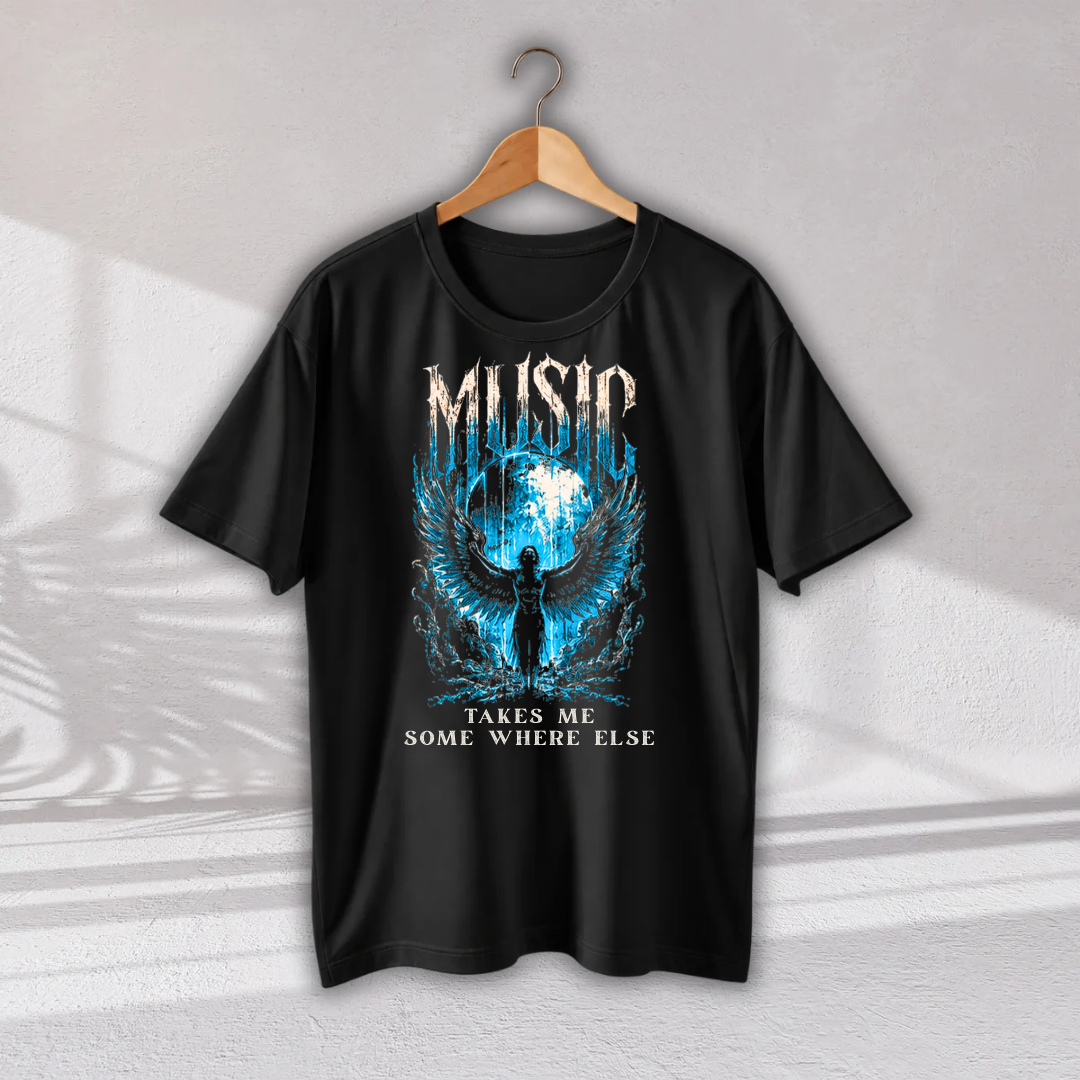 A black short-sleeve graphic t-shirt hanging on a wooden hanger against a light gray wall. The shirt features a blue and white graphic of an angel with wings, a globe, and the text 'MUSIC TAKES ME SOME WHERE ELSE'.