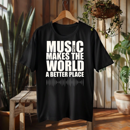 A black short-sleeve graphic t-shirt hanging on a wooden hanger against a rustic wood-paneled wall with potted plants. The shirt features the text 'MUSIC MAKES THE WORLD A BETTER PLACE' in bold white capital letters with a white soundwave graphic underneath.