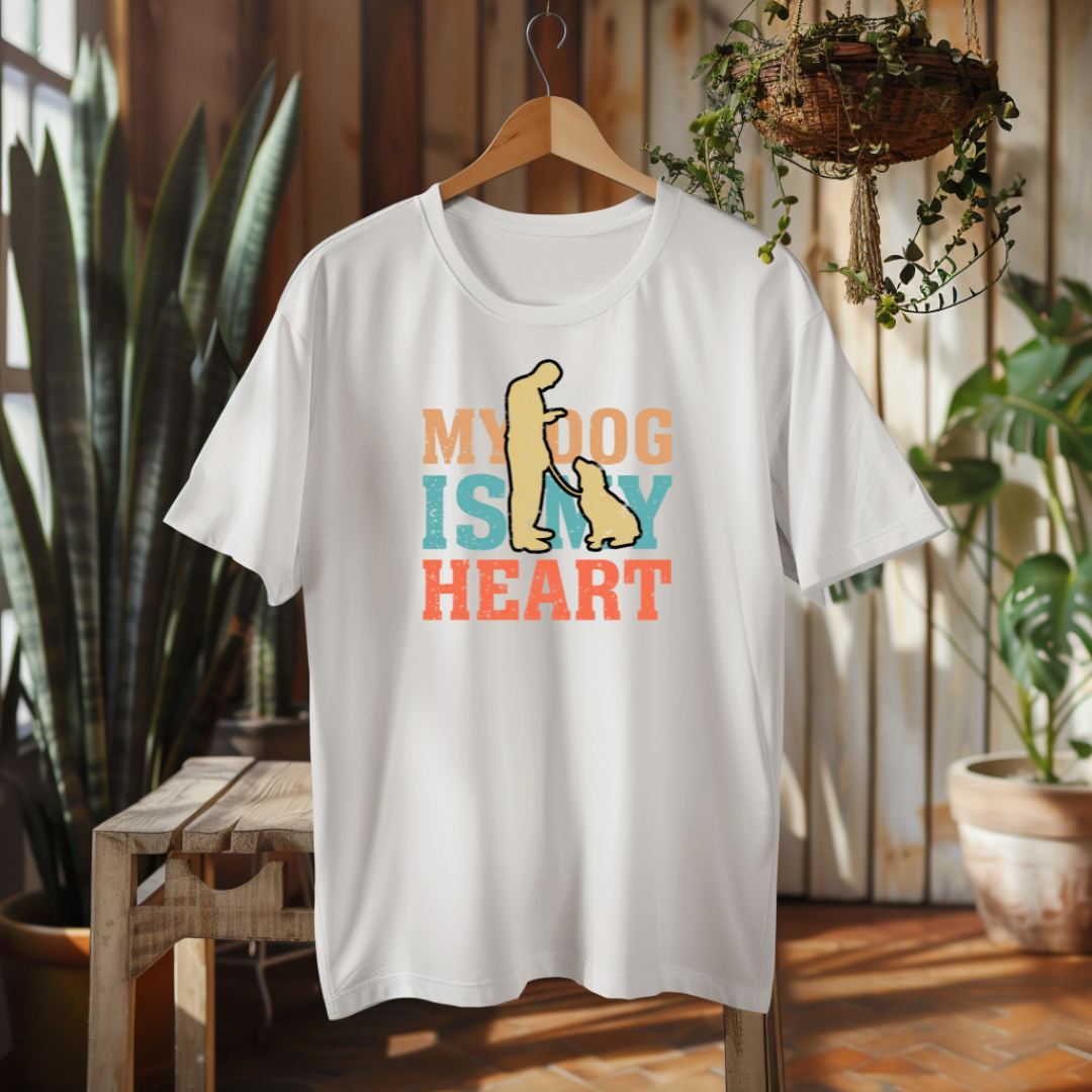 White t-shirt with 'My dog is my heart' design on a hanger in a room with plants.