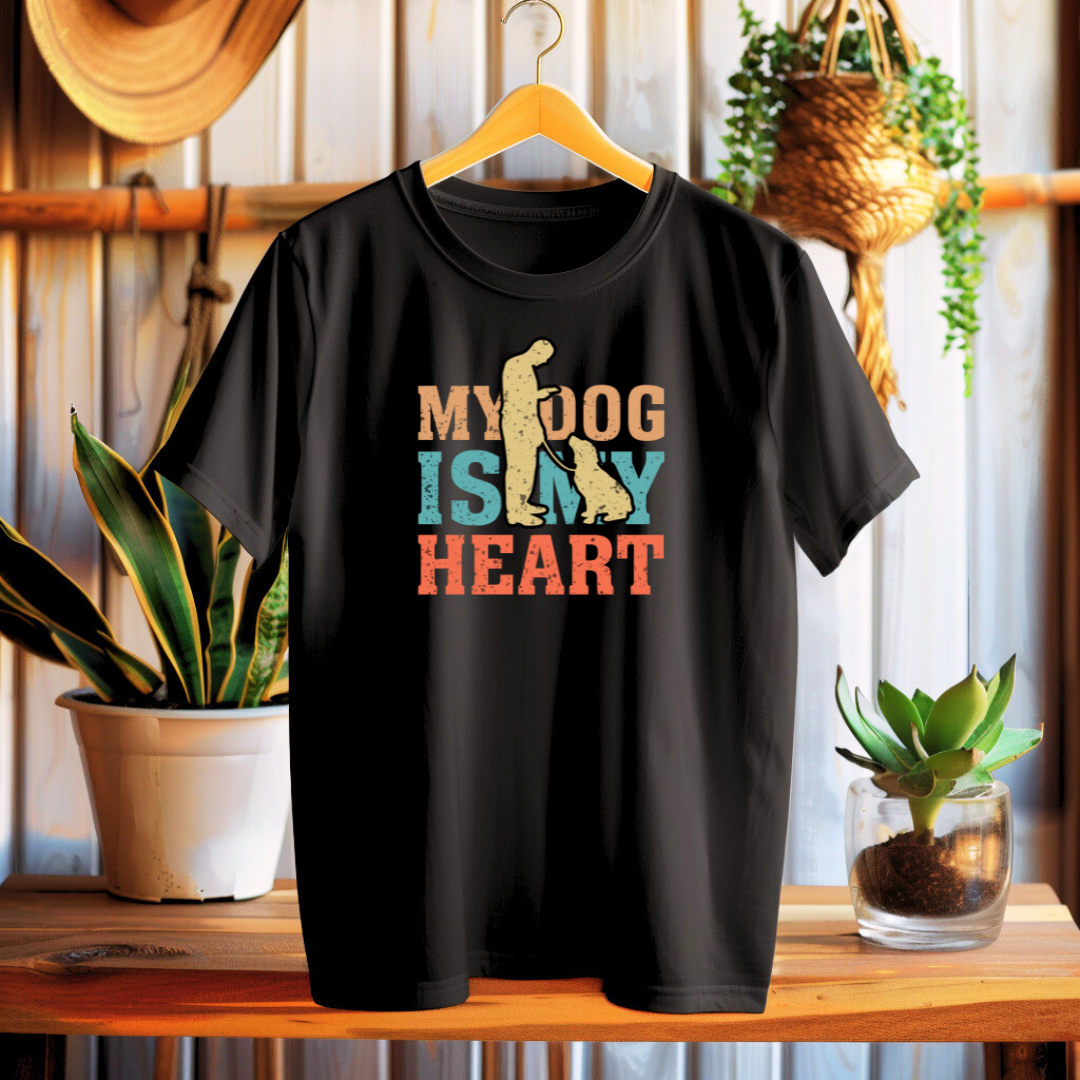 Black t-shirt with 'My dog is my heart' design on a wooden table with plants in the background