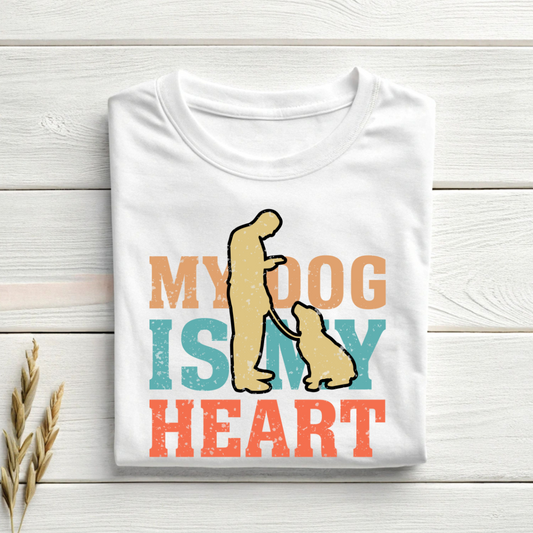White t-shirt with dog graphic and text 'My dog is my heart' on a wooden surface.