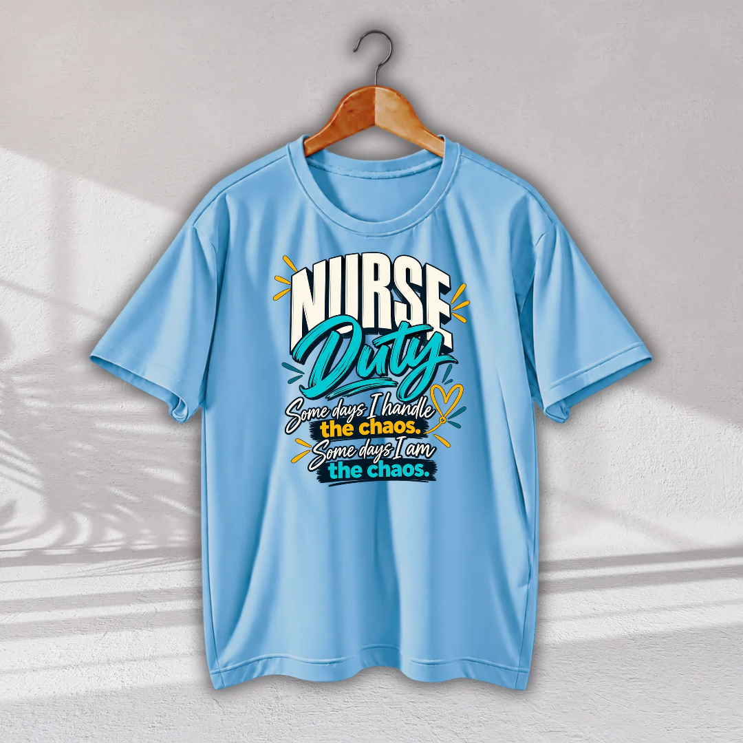 A light blue short-sleeve t-shirt hanging on a wooden hanger against a light gray wall with soft shadow patterns. The shirt features a graphic on the chest that reads 'NURSE Duty' in stylized white and teal lettering, with the phrase 'Sometimes I handle the chaos.
