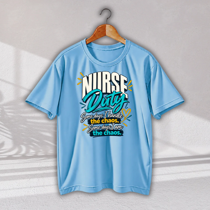 A light blue short-sleeve t-shirt hanging on a wooden hanger against a light gray wall with soft shadow patterns. The shirt features a graphic on the chest that reads 'NURSE Duty' in stylized white and teal lettering, with the phrase 'Sometimes I handle the chaos.