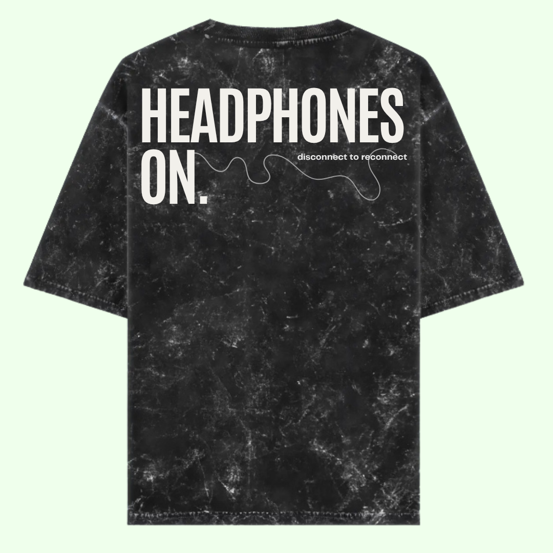 Black tie-dye t-shirt with 'HEADPHONES ON.' text on a light green background