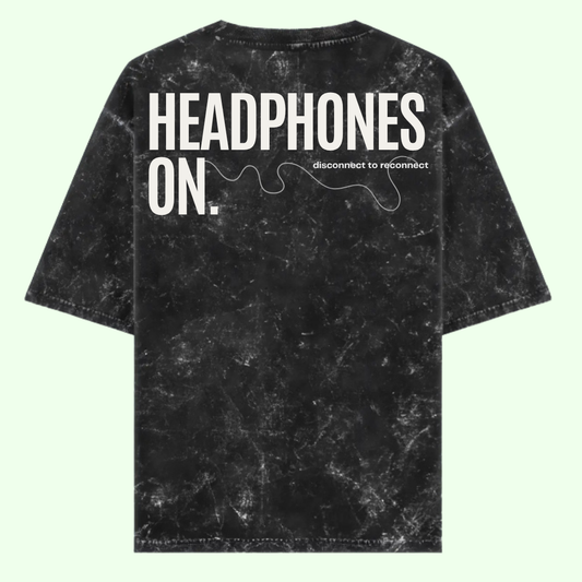 Black tie-dye t-shirt with 'HEADPHONES ON.' text on a light green background