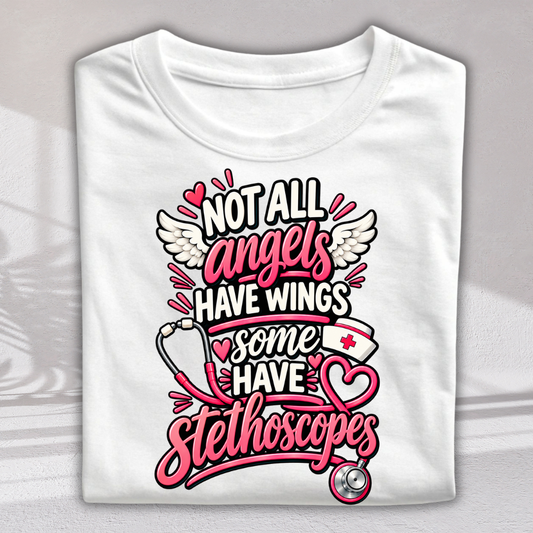 A folded white t-shirt with a graphic print that reads 'NOT ALL angels HAVE WINGS some HAVE stethoscopes' in pink, black, and white lettering, decorated with angel wings, a stethoscope, and hearts.
