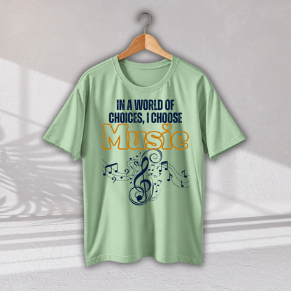 A light green short-sleeve t-shirt hanging on a wooden hanger against a light gray wall. The shirt features a graphic print with the text 'IN A WORLD OF CHOICES, I CHOOSE Music' in navy blue and orange, accompanied by a navy blue treble clef and musical notes design.