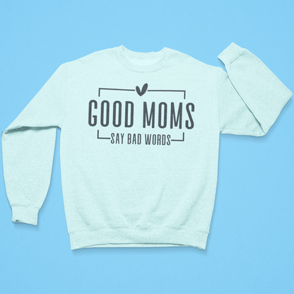 Light blue sweatshirt with text 'GOOD MOMS SAY BAD WORDS' on a light blue background