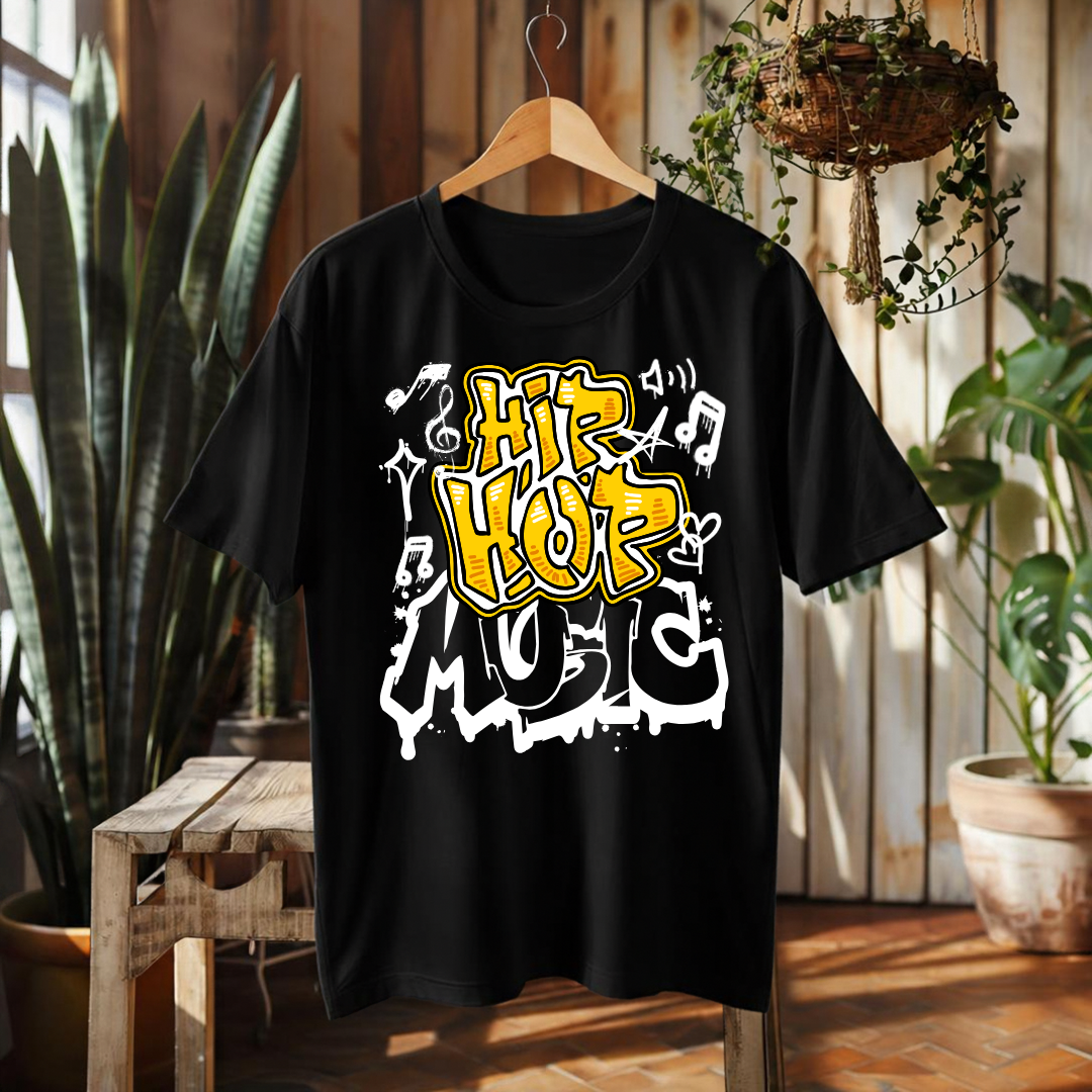 A black short-sleeve graphic t-shirt hanging on a wooden hanger in a rustic indoor setting with plants and wood paneling. The shirt features a bold graphic print reading 'Hip Hop Music' in yellow and white graffiti-style lettering with musical notes.