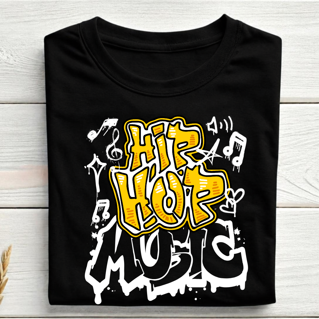 A black short-sleeve T-shirt laid flat on a light wood plank background, featuring a large graffiti-style graphic that reads 'HIP HOP MUSIC' in yellow, white, and black, with musical notes and symbols.